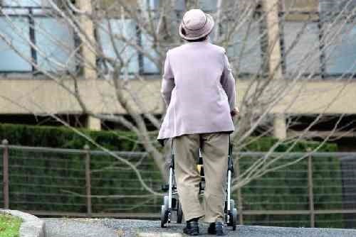 シルバーカーで一人で歩く高齢者